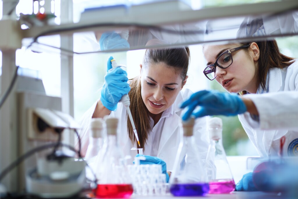 two female scientists looking at vials